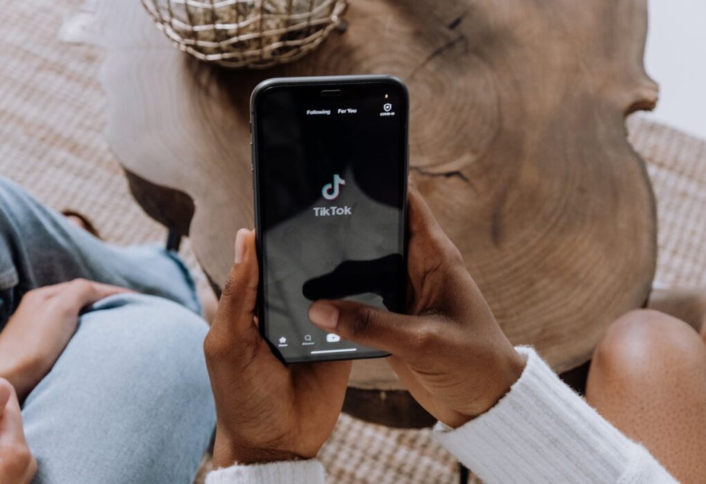 Una persona que abre TikTok en su teléfono para representar la prohibición de TikTok fuente de la imagen: https://www.pexels.com/photo/person-holding-black-android-smartphone-5081930/